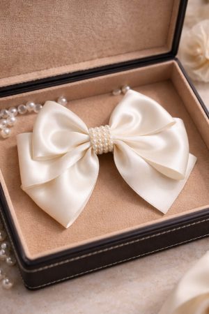 Ivory satin bow hair clip with pearl detailing for bridal and party wear
